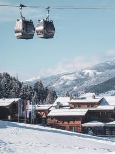 a couple of ski lifts flying over a snow covered slope at CHALET VILLAGE ZAGLGUT, fantastic views, Ski in Ski-out in winter, air conditioning in summer in Kaprun