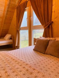 Schlafzimmer mit einem Bett und einem großen Fenster in der Unterkunft Villa in Rugove, Kosovo in Lekaj