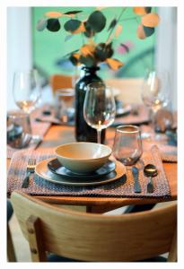 uma mesa com uma tigela e um vaso com copos de vinho em Poilsio namelis 