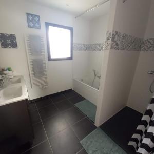 a bathroom with a tub and a sink and a shower at A L'OMBRE DES 2 TILLEULS maison d'hôtes adults only in Sainte-Pazanne