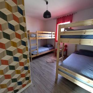 a room with two bunk beds and a wall with a mural at A L'OMBRE DES 2 TILLEULS maison d'hôtes adults only in Sainte-Pazanne