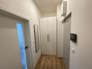 korytarz z białymi szafkami i lustrem w obiekcie Historic Center Brno Apartment w mieście Brno +8 zdjęć