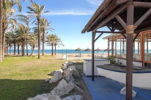 une maison sur la plage avec des palmiers et l'océan dans l'établissement ROMANTIC TORREMOLINOS, à Torremolinos