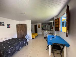 a room with a bed and a blue table at Casa na Orla - Praia de Gaibu! in Cabo de Santo Agostinho