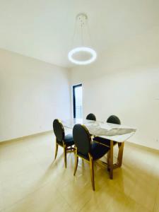 una sala da pranzo con tavolo e 4 sedie di Century Park Hotel & Residences a Kigali
