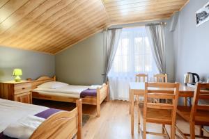 卡爾帕奇的住宿－Rezydencja Karnat I i II，一间卧室配有两张床和一张桌子及椅子