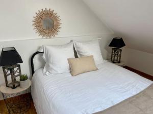 a bedroom with a white bed with a mirror on the wall at Le Cosy Troyen secteur calme 4 personnes parking privé in Troyes