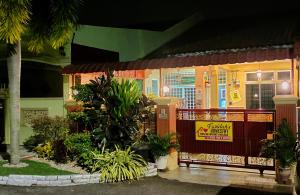 une maison avec un panneau à l'avant dans l'établissement Faridah Homestay Melaka Muslim Friendly, à Kampong Bukit Katil