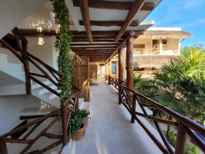 einen Flur eines Hauses mit einem Balkon mit Pflanzen in der Unterkunft Tierra Mia Boutique Hotel in Holbox