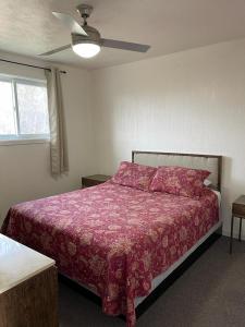 1 dormitorio con 1 cama con edredón rojo en Welcome Inn, en Mattawa