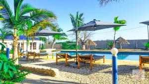 a resort with a pool with chairs and umbrellas at Jabali Bungalows Lodge in Paje