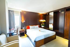 ein Schlafzimmer mit einem Bett, einem Schreibtisch und einer Couch in der Unterkunft Bonka Hotel Luxury Quận 5 HCM in Ho-Chi-Minh-Stadt