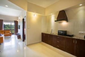 uma cozinha com um lavatório e um micro-ondas num quarto em Sea Pearl Beach Resort & Spa Cox's Bazar em Cox's Bazar