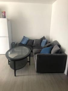 バーミンガムにあるCosy 3 Bedroom NEC House, Free WiFi, Netflix, Driveway Parking, Sleeps 6, Ideal for Families, Contractors & Corporates, Renovated To High Standard!のソファとガラスのテーブルのあるリビングルーム