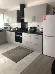バーミンガムにあるCosy 3 Bedroom NEC House, Free WiFi, Netflix, Driveway Parking, Sleeps 6, Ideal for Families, Contractors & Corporates, Renovated To High Standard!の白いキャビネットと白い冷蔵庫のあるキッチン +15枚の写真