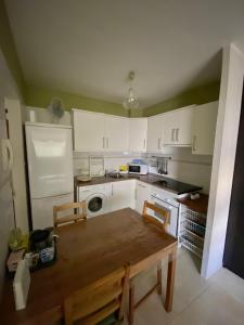 a kitchen with white cabinets and a wooden table and chairs at Los Menceyes Yaral in Candelaria