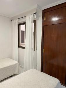 - une chambre avec 2 lits et une porte en bois dans l'établissement Просторная квартира рядом с морем в хорошем районе, à Torrevieja