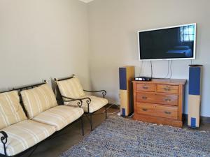 a living room with a couch and a flat screen tv at Rustic Country Cottage in White River