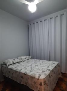 1 dormitorio con 1 cama y ventilador de techo en Fenix Canasvieiras 200 m Mar en Florianópolis