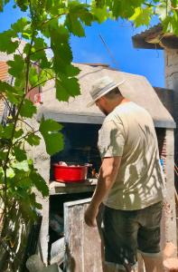 a man standing in front of an outdoor oven at Alojamiento Gonzalez Paz in Puerto Madryn