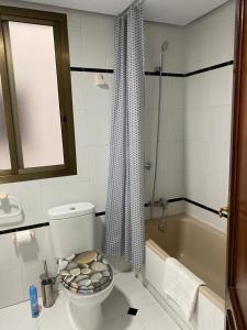 La salle de bains est pourvue de toilettes et d'une baignoire. dans l'établissement Просторная квартира рядом с морем в хорошем районе, à Torrevieja