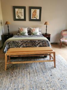 Un dormitorio con una cama con un banco al final. en Rustic Country Cottage en White River