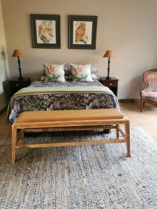 una camera da letto con un letto con una panca alla fine di Rustic Country Cottage a White River