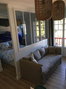 a living room with a couch and a mirror at APPARTEMENT REFAIT A NEUF, IDEALEMENT SITUÉ in La Baule