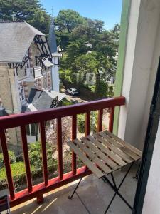 un banc sur un balcon avec vue sur une maison dans l'établissement APPARTEMENT REFAIT A NEUF, IDEALEMENT SITUÉ, à La Baule