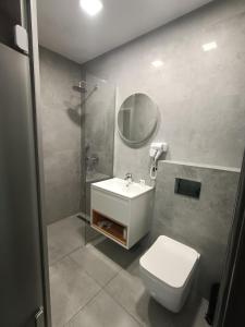 La salle de bains est pourvue de toilettes, d'un lavabo et d'un miroir. dans l'établissement Dom Przyjęć EWA, à Piece