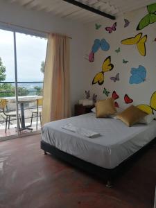 a bedroom with a bed with butterflies on the wall at Casa chill out in Minca