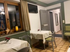 ein Restaurant mit 2 Tischen, Stühlen und Fenstern in der Unterkunft Rosi`s in Maria Alm am Steinernen Meer