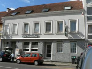 ein rotes Auto, das vor einem Gebäude parkt in der Unterkunft Hotel am Schenkelberg in Saarbrücken