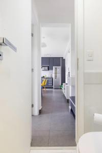 un pasillo que conduce a una cocina con encimeras blancas y una habitación en Apartamento em São Paulo, Vila Madalena, en São Paulo