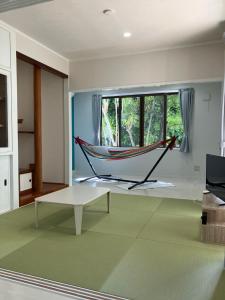 a hammock in the middle of a living room at Hana Villa 備瀬のや in Motobu