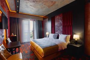 a hotel room with a bed and a desk and a chair at Tapis Rouge Design Boutique Hotel in Batumi