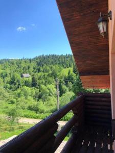 einen Balkon eines Hauses mit Waldblick in der Unterkunft Шервуд in Myta