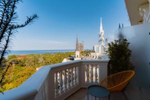 a balcony with a view of the ocean and buildings at Tapis Rouge Design Boutique Hotel in Batumi