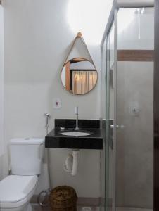 a bathroom with a sink and a mirror at Kalug - Chalé Chão de Trancoso Studios in Trancoso