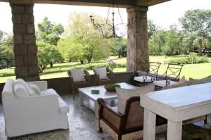 a patio with couches and a table and chairs at Torburnlea Homestead Luxury Accommodation in Nelspruit