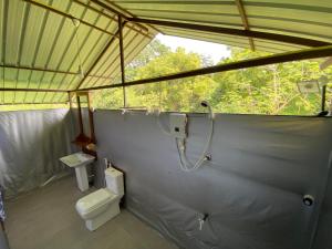 een badkamer met een douche en een toilet in een tent bij mango villa wilpattu in Nekattegama