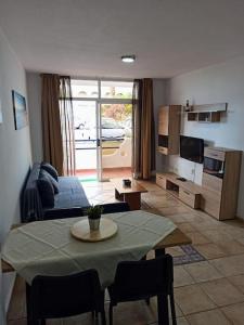 a living room with a table and a couch at Casa de Simo · Sol, Relax y diversión in Adeje