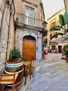 un edificio con puerta de madera, mesa y sillas en HomeClass Mercantile, en Bari