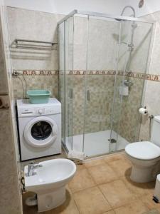 a bathroom with a washing machine and a toilet at Casa de Simo · Sol, Relax y diversión in Adeje