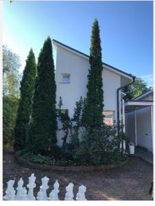 a garden with trees and a white board in front of a house at Pieni huone 1 km jokirannasta in Turku