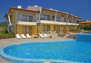 a villa with a swimming pool in front of a building at Montemar Villas in Sunny Beach
