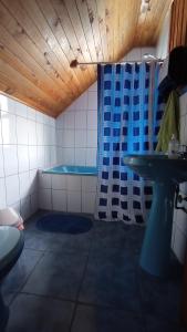 y baño con ducha azul y lavamanos. en Hostal Casa Damasco, en Ancud