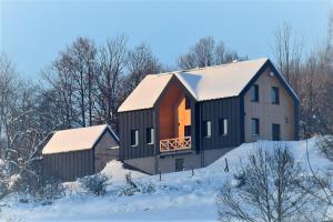 una casa en una colina en la nieve en Osada Dzikie Wino, en Budzów