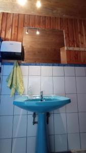 a bathroom with a blue sink and white tiles at Hostal Casa Damasco in Ancud