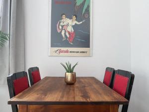 a wooden table with chairs and a picture on the wall at Stilvolle 2 Zimmer Wohnung mit Küche, TV, Waschmaschine in Leipzig